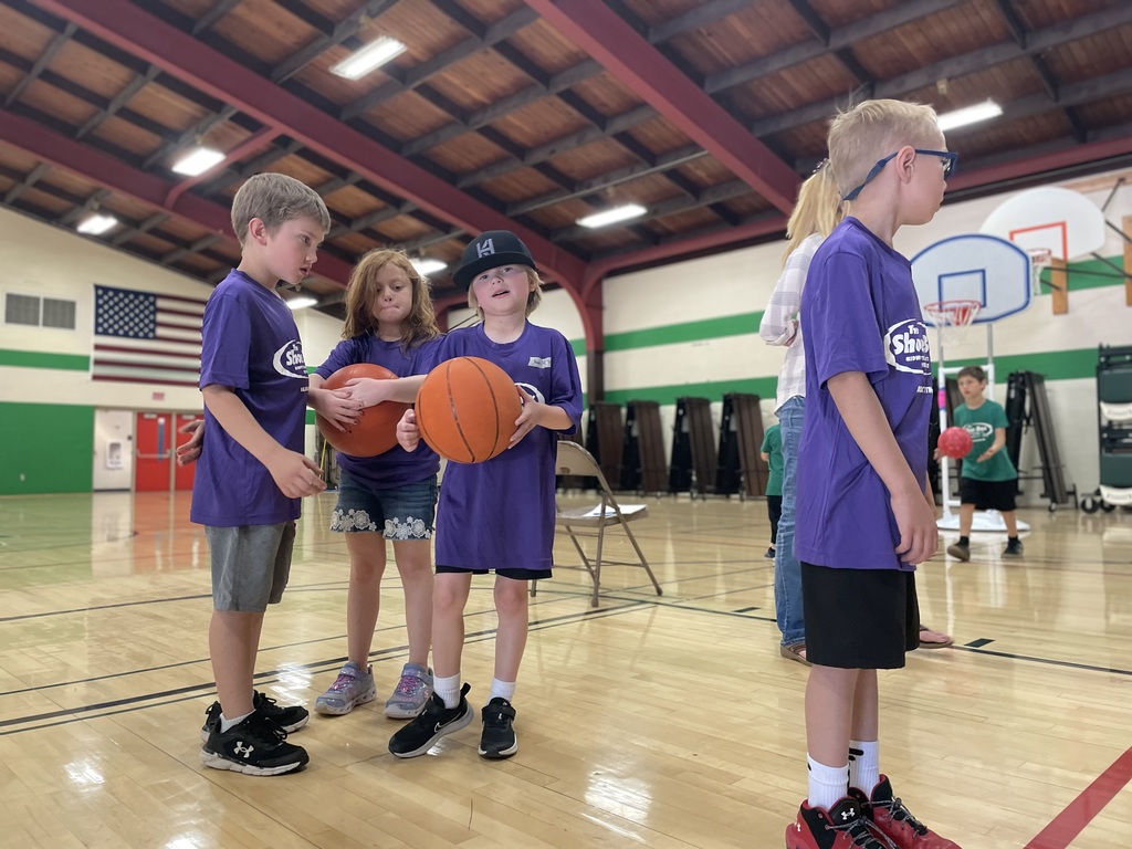 students in purple shirts playing basketball on field day
