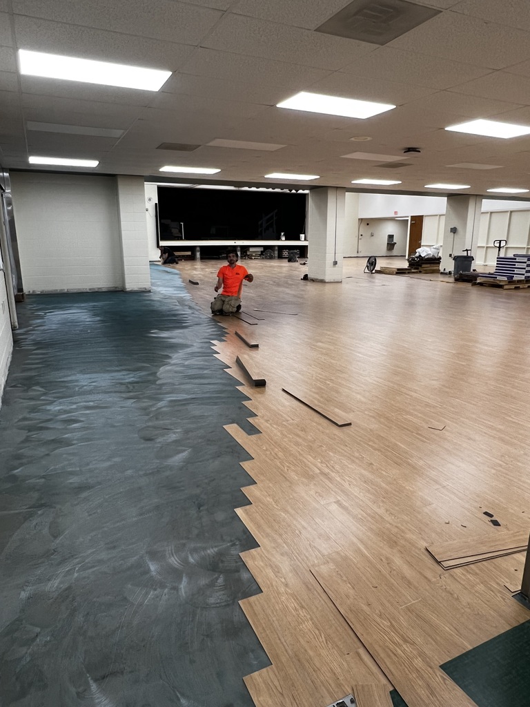 Man installing new floor in cafeteria