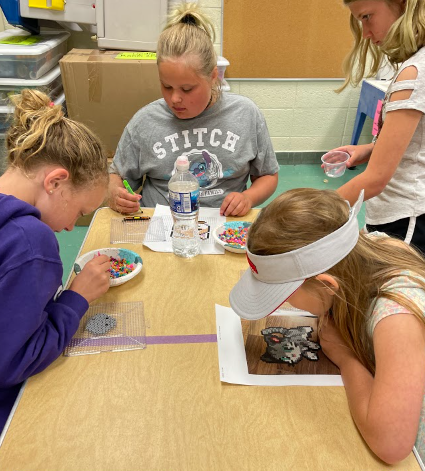 4 students working with beads at a table
