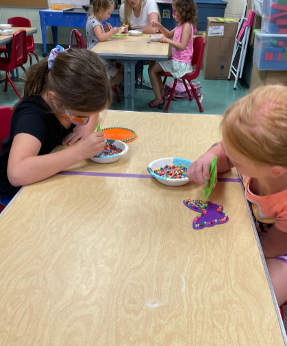 2 students at a table working with beads