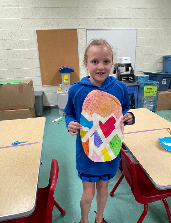 Girl holding an Easter egg made out of construction paper